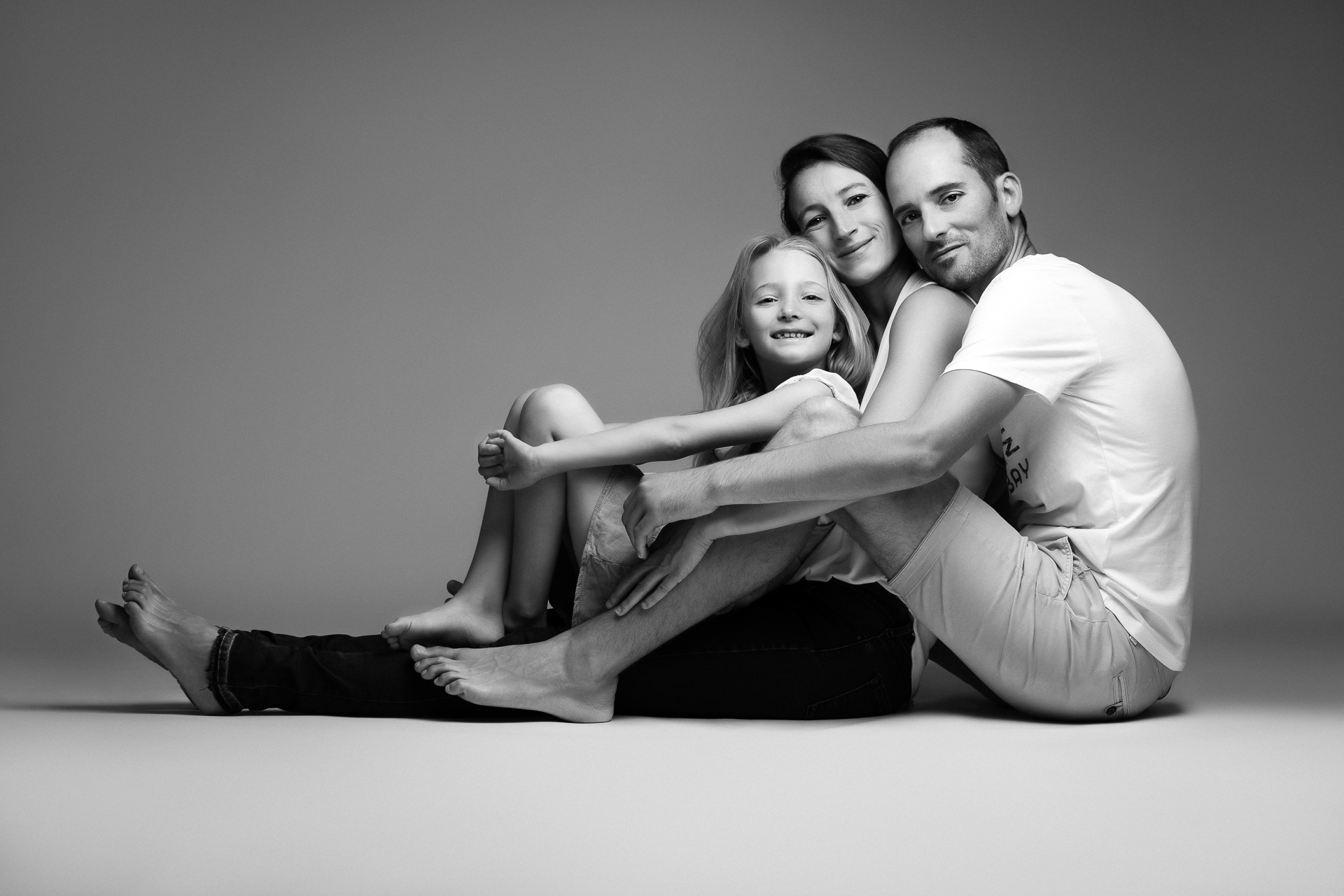 Portrait d'une famille recomposée, câlin avec leur fille