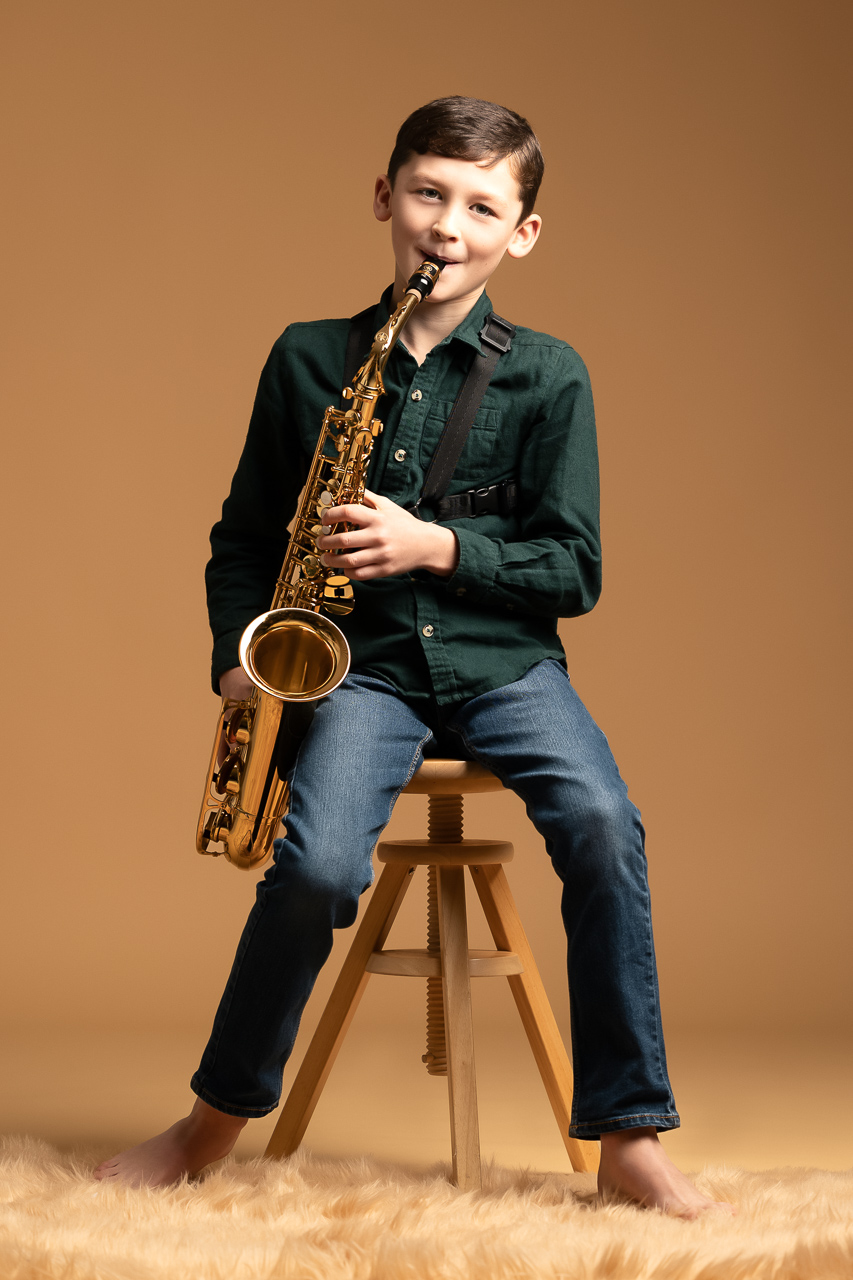 Portrait d'enfant, jeune garçon saxophoniste en tenue habillée pour immortaliser les passions et activité de vos enfants, telle que la musique
