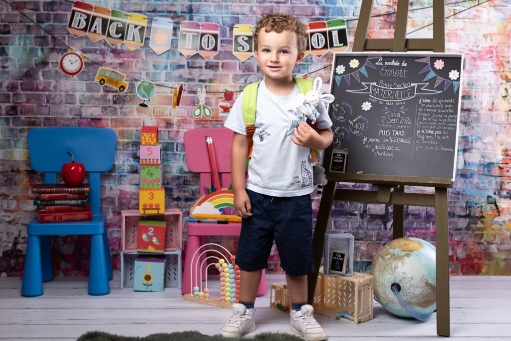 Séance photo pour la rentrée scolaire 2025, dans un décor coloré et enfantin, peps pour se souvenir de cette grande étape de votre enfant, réalisé à Pusignan par Studio Evidence - photographe professionnelle à Pusignan, dans le Rhône, aux portes de Lyon
