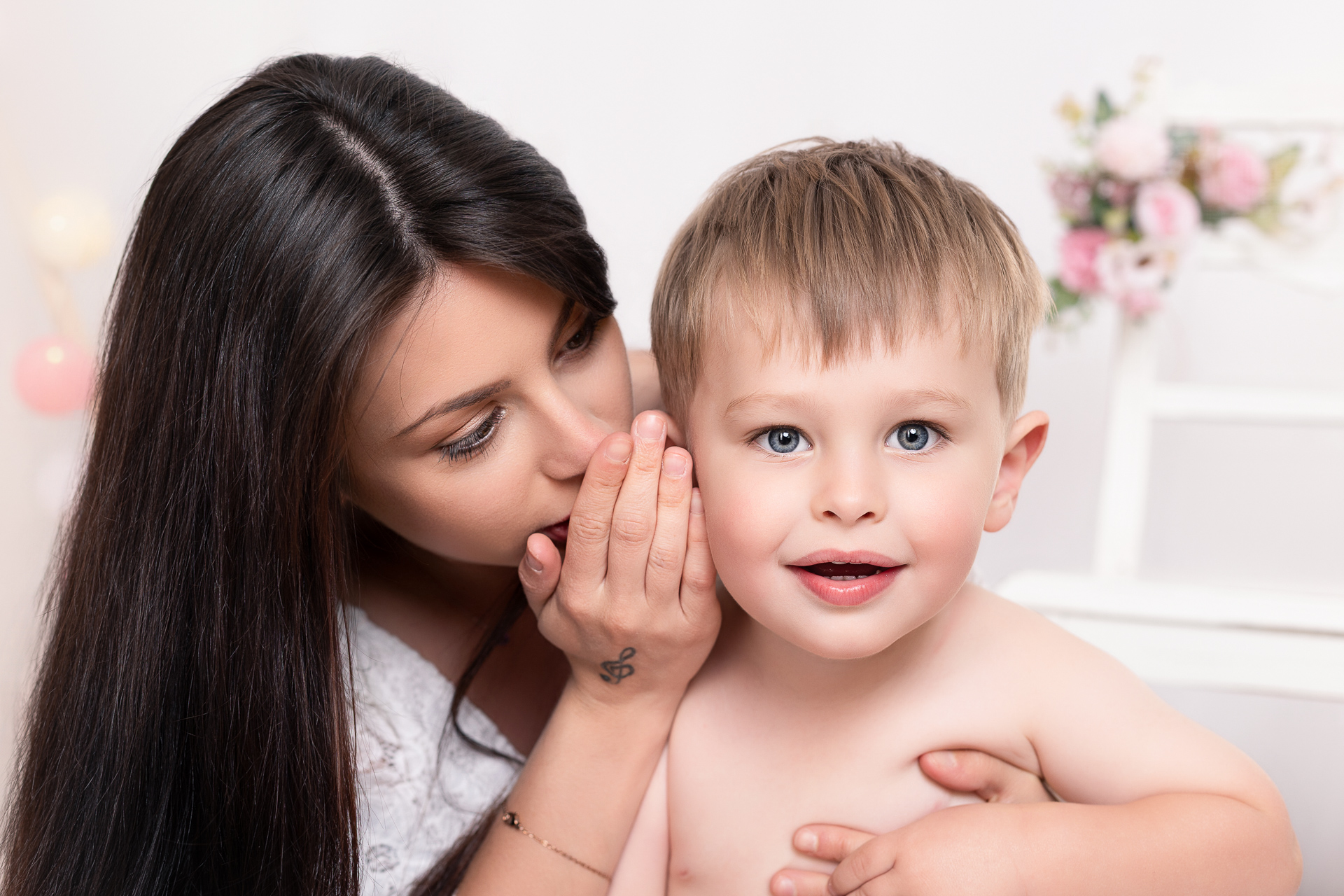 Maman chuchotant un secret à l'oreille de son enfant — Studio Evidence